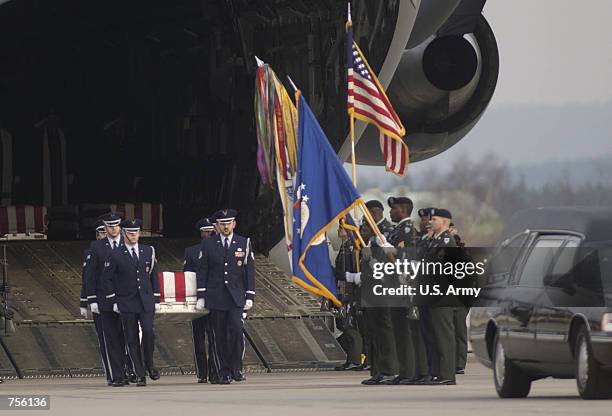 Military honor guard carries the remains of a U.S. Serviceman off a C-17 Globemaster III March 5, 2002 in Ramstein Air Base, Germany. The U.S....