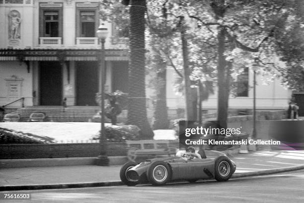 Eugenio Castellotti swings his Ferrari-Lancia through the morning shadows of Casino Square in the early morning practice session before the Monaco...