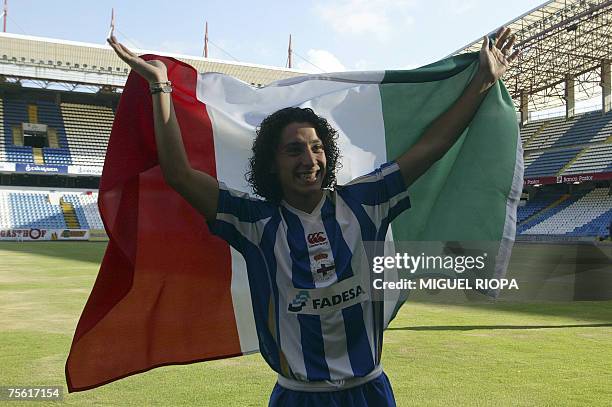 Mexican football player Andres Guardado salutes to fans with a flag of Mexico during his presentation ceremony as new Deportivo Coruna's player at...