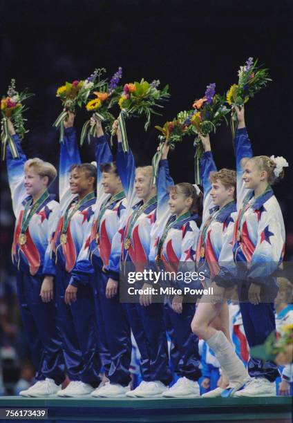 Amanda Borden, Dominique Dawes, Amy Chow, Jaycie Phelps, Dominique Moceanu, Kerri Strug with leg in plaster and Shannon Miller celebrate with their...