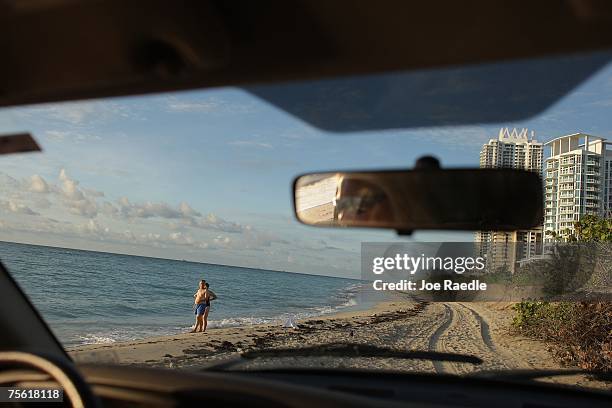 Miami-Dade county sea turtle expert Selina Mills drives along the beach as she tries to spot sea turtle nests July 24, 2007 in North Miami, Florida....