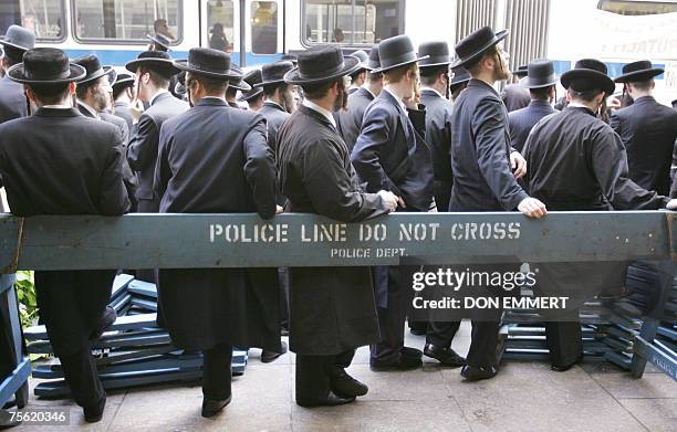 New York, UNITED STATES: Orthodox Jews stand against a police barricade during an anti-Zionist rally 24 July 2007 in New York, to protest what they...