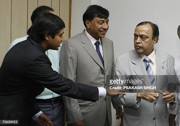 Mittal Investments Chairman Lakshmi N Mittal smiles as his son Aditya Mittal talks with Indian Minister for Petroleum and Natural Gas Murali Deora...