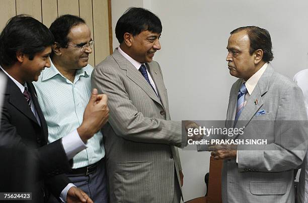 Mittal Investments Chairman Lakshmi N. Mittal shakes hands with Indian Minister for Petroleum and Natural Gas Murali Deora as his son Aditya Mittal...