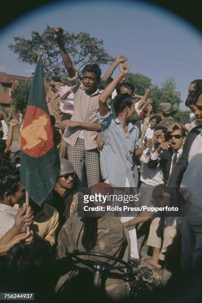View of Bangladeshi guerillas gleefully waving the Bangladesh flag as they crowd on and around an Indian Army jeep in Dacca in December 1971. The...
