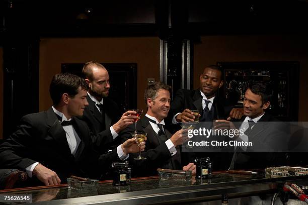 men in dinner jackets drinking cocktails in bar - tuxedo party stock pictures, royalty-free photos & images