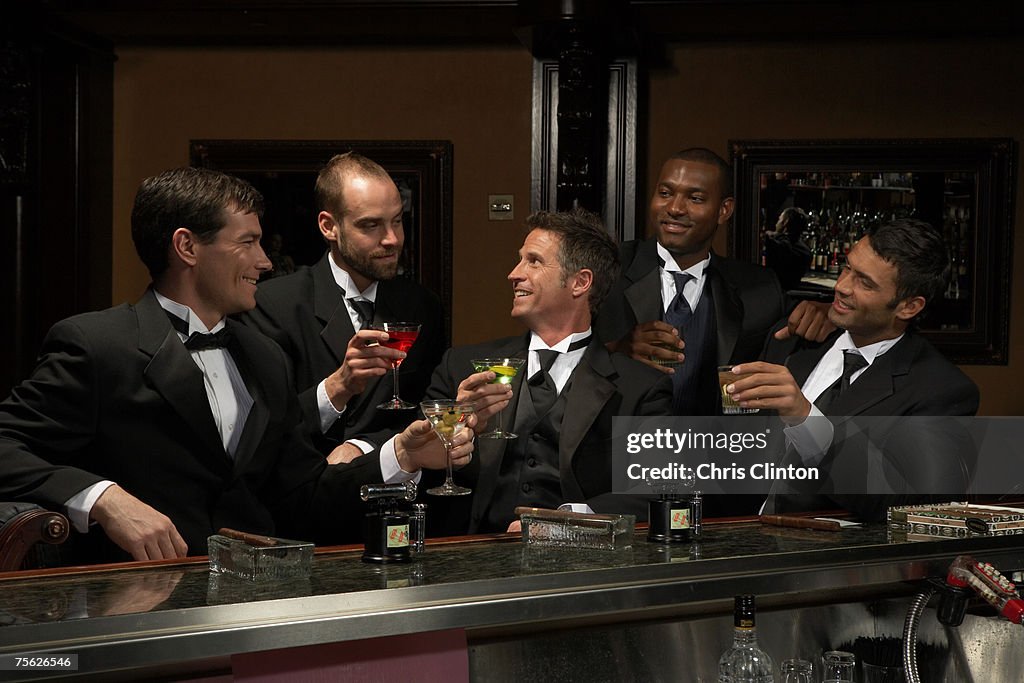 Men in dinner jackets drinking cocktails in bar