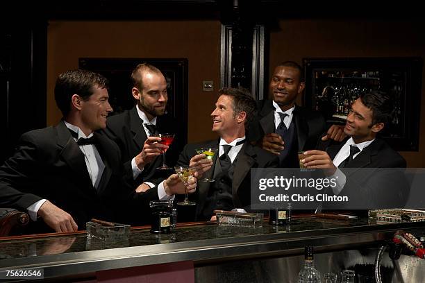 men in dinner jackets drinking cocktails in bar - smoking photos et images de collection