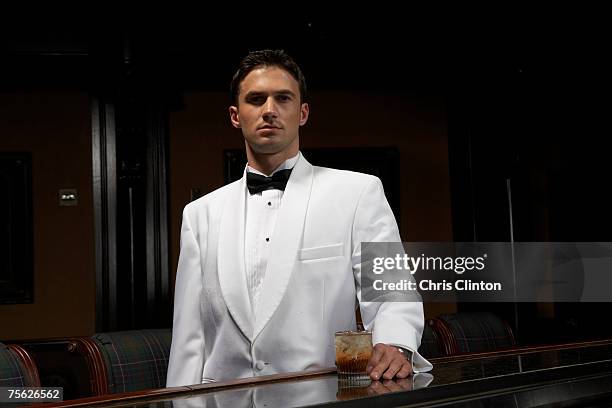 man in dinner jacket standing at bar with drink, portrait - smoking imagens e fotografias de stock