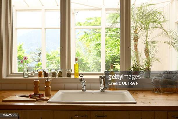 cooking tools beside sink in kitchen - kitchen window stock-fotos und bilder