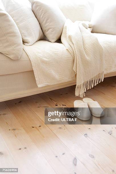 sofa with matching slippers in living room - blanket stock-fotos und bilder