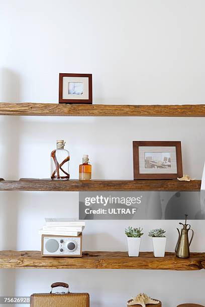 framed photographs, decorative jars and potted plants on natural wooden shelves - medium group of objects stock pictures, royalty-free photos & images