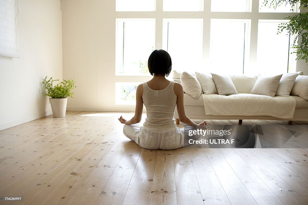 Young woman performing yoga pose in living room