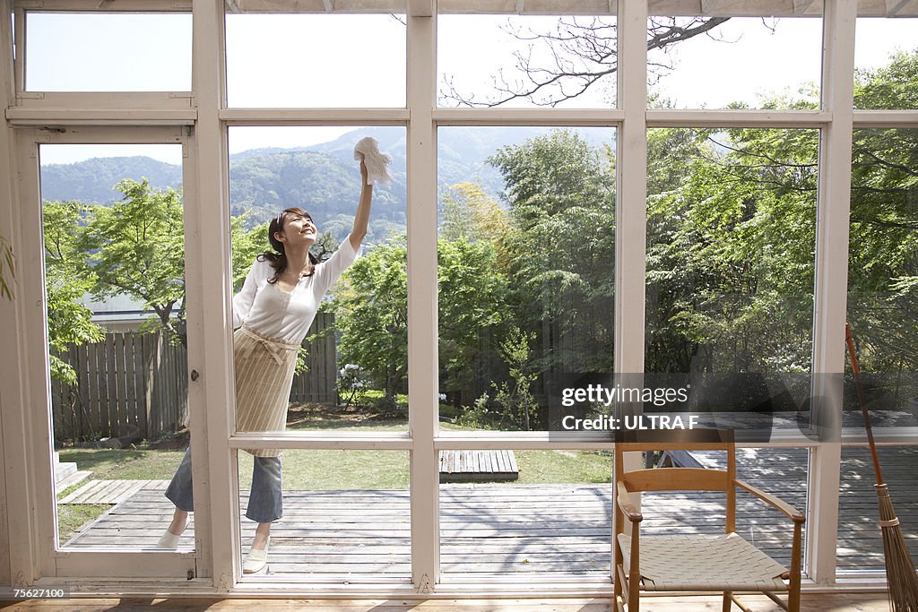 Woman on patio cleaning windows