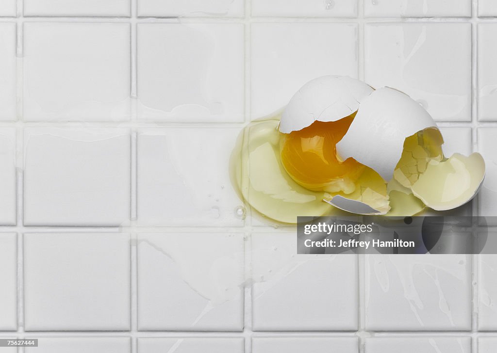 Broken egg on white tiles