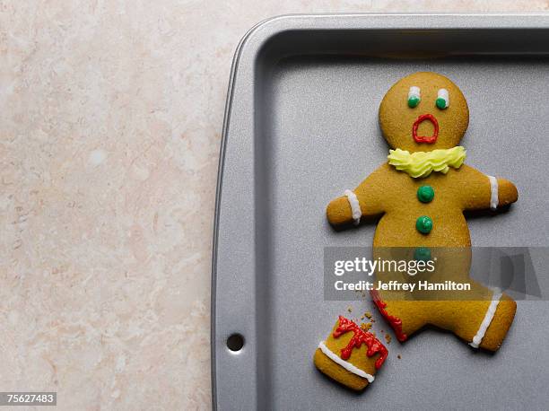 gingerbread man with broken leg on baking sheet, close-up - ジンジャーブレッドマン ストックフォトと画像