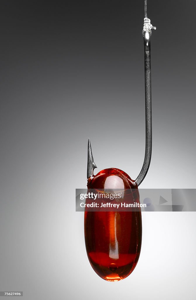 Red capsule on fishing hook, close-up