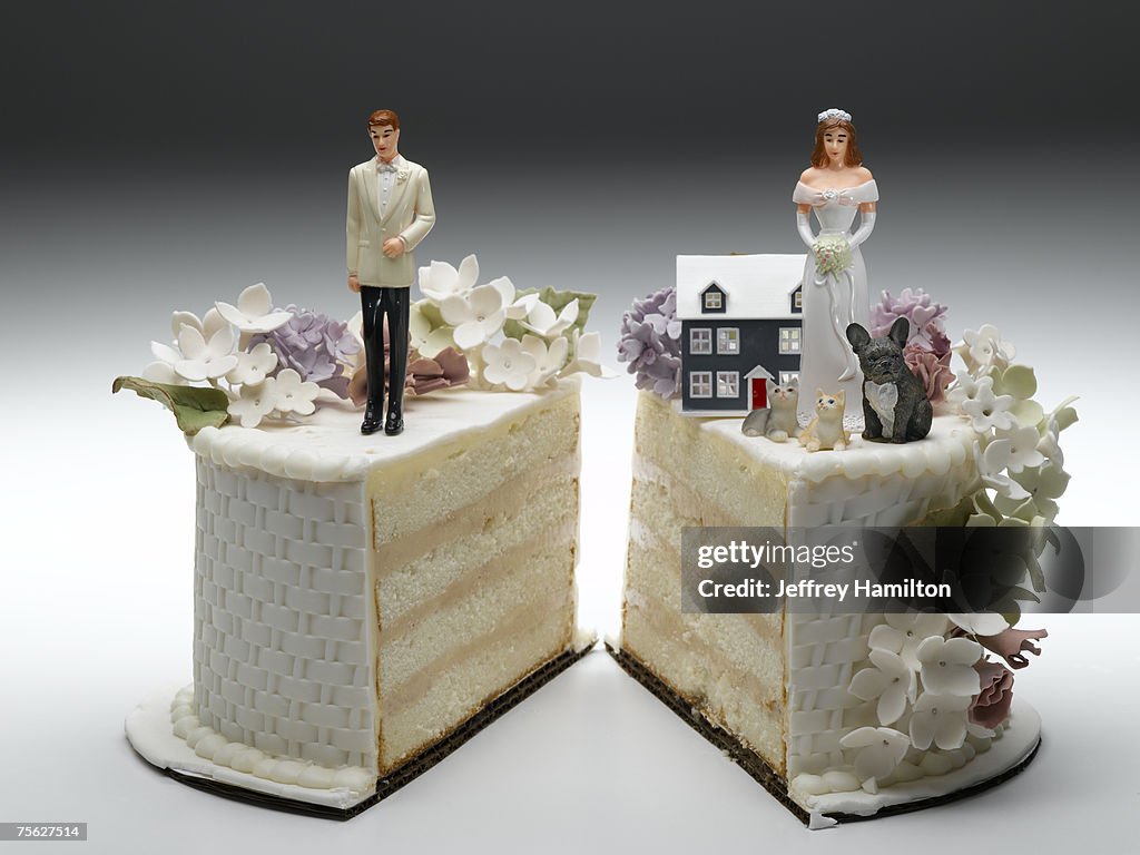 Bride and groom figurines standing on two separated slices of wedding cake