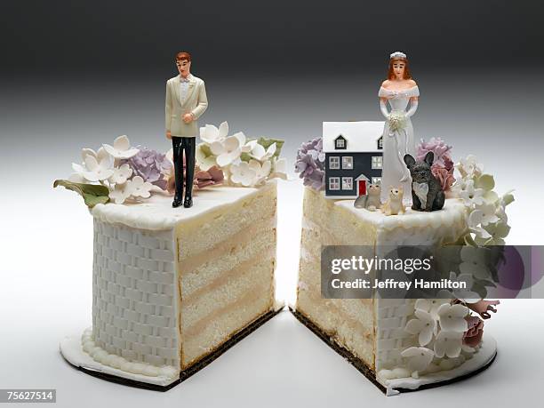 bride and groom figurines standing on two separated slices of wedding cake - hochzeitstorte stock-fotos und bilder