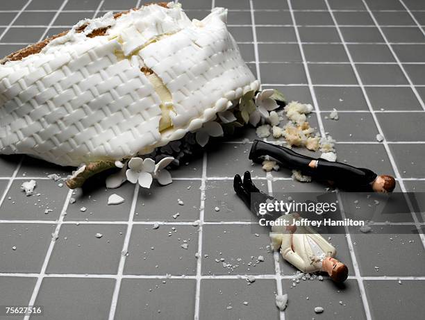 two groom figurines lying at destroyed wedding cake on tiled floor - bröllopstårtsfigur bildbanksfoton och bilder