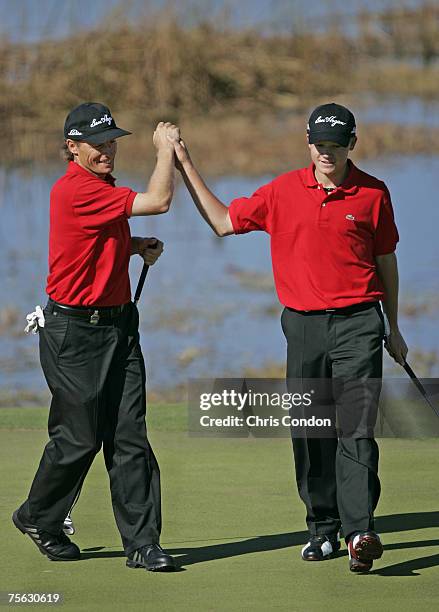 Bernhard Langer birdies the 17th hole and reacts with his son, Stefan in the first round of the MBNA Father/Son Challenge at ChampionsGate golf...