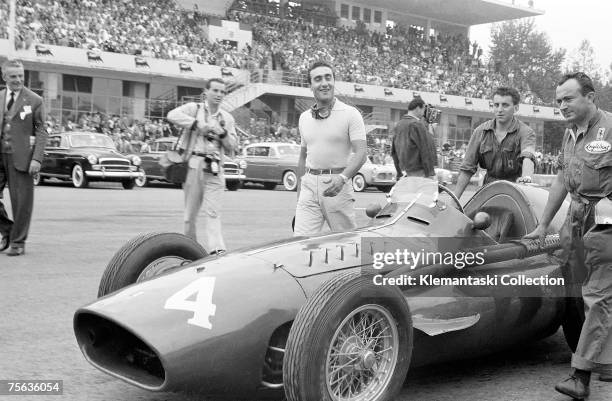 Racing driver Eugenio Castellotti with his Ferrari 'Squalo' walking to the grid before the start of the Italian Grand Prix at Monza, 11th September...