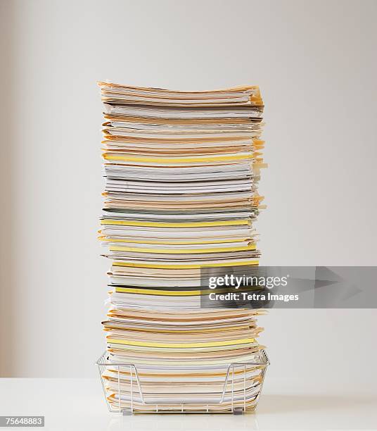 large stack of paperwork in wire basket - montón fotografías e imágenes de stock