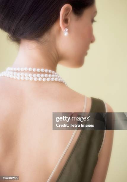 rear view of woman wearing pearl necklace - pearl necklace stock pictures, royalty-free photos & images