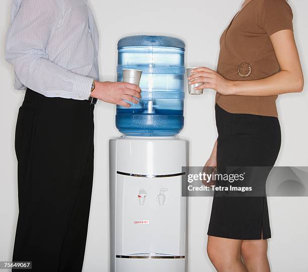 businesspeople next to water cooler - trinkwasserbehälter stock-fotos und bilder