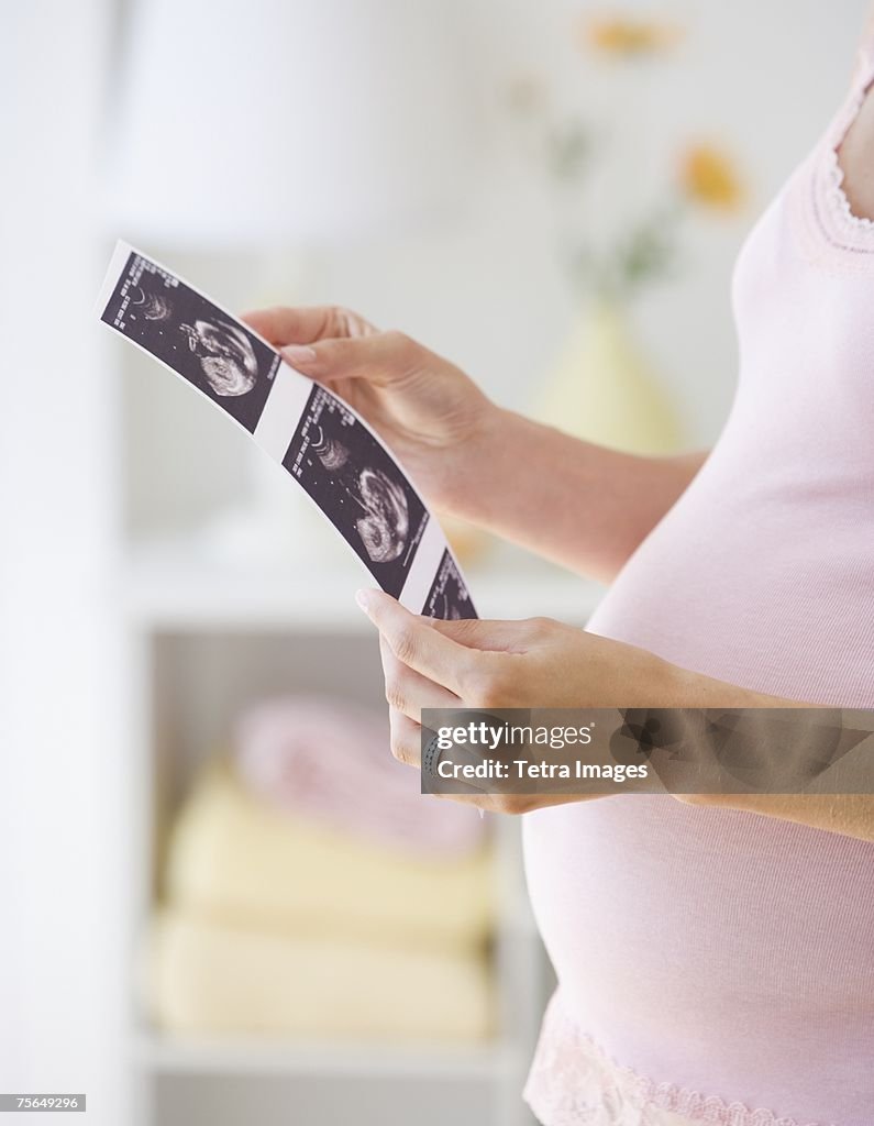 Pregnant woman looking at ultrasound printout