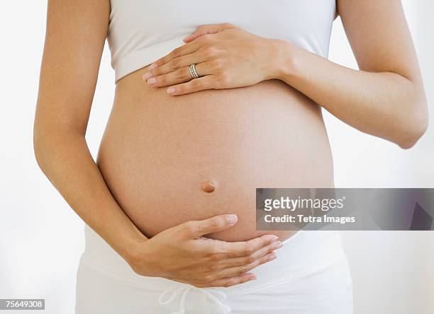 pregnant woman with hands on belly - pregnant belly stockfoto's en -beelden