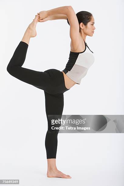 woman practicing yoga - tetra images stock-fotos und bilder