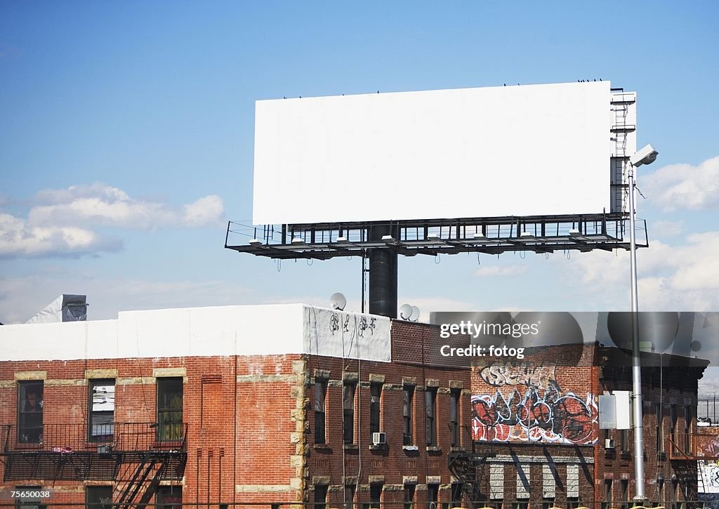 Blank billboard over urban buildings