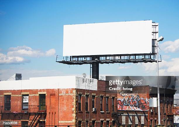 blank billboard over urban buildings - billboard stock pictures, royalty-free photos & images