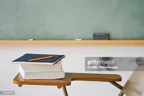 books and pencil on desk in classroom - text book stockfoto's en -beelden