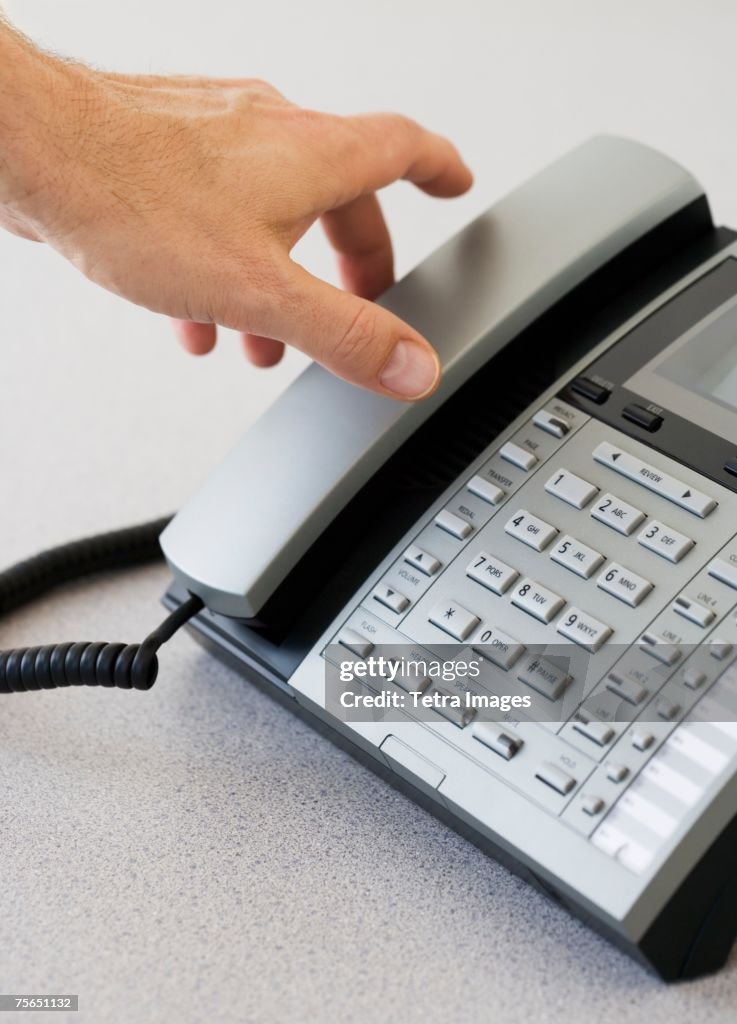 Man reaching for telephone receiver