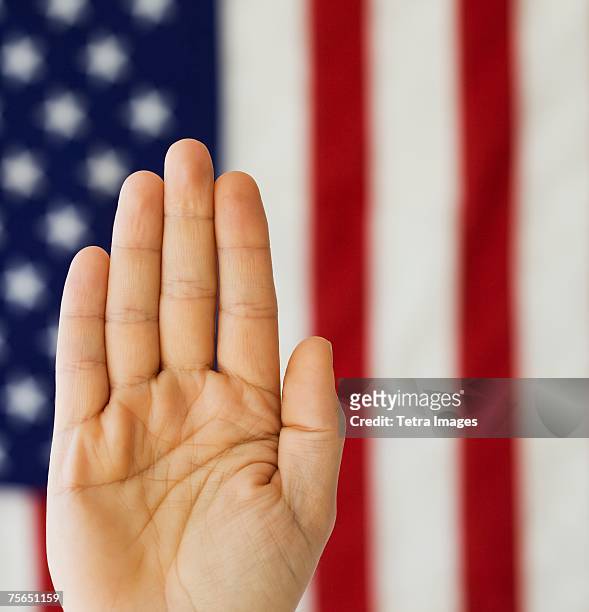 man's hand up in front of american flag - oath fotografías e imágenes de stock