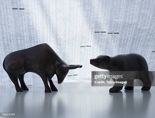 bear and bull figurines facing each other - börsenbaisse stock-fotos und bilder
