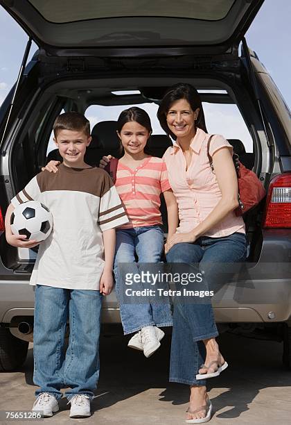 mother and children on tailgate of truck - soccer mom stock pictures, royalty-free photos & images