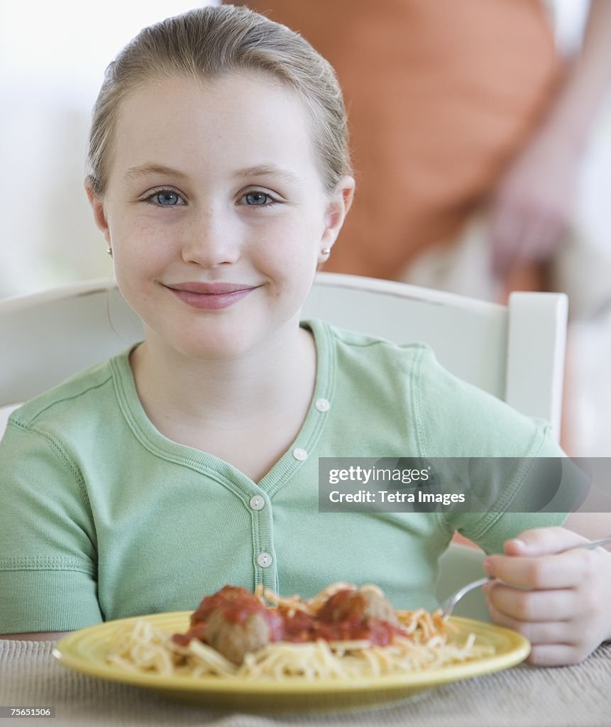 Girl eating spaghetti and meatballs