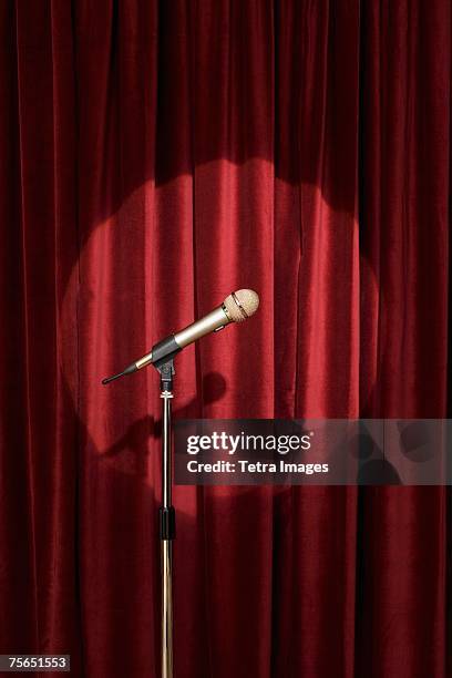 spotlight on microphone on stage - stage curtain stock pictures, royalty-free photos & images