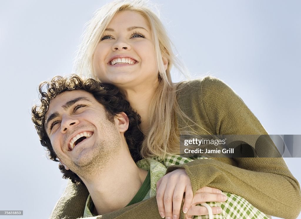 Man giving girlfriend piggyback ride