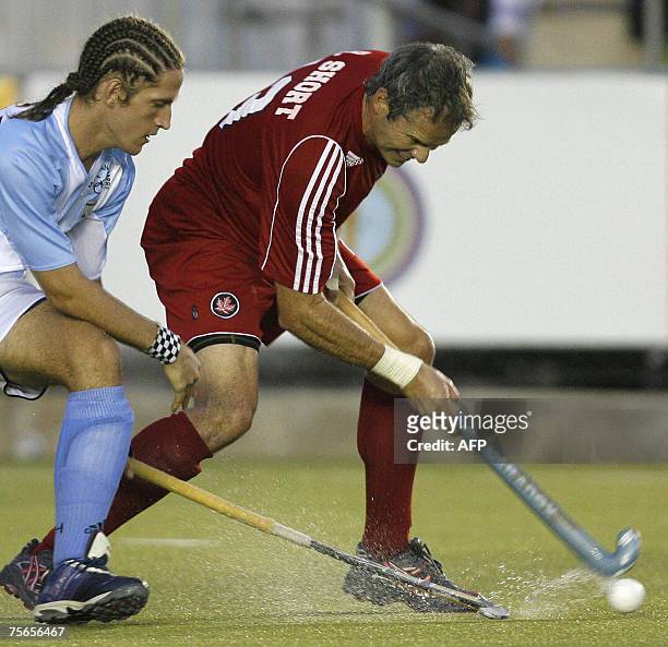 Rio de Janeiro, BRAZIL: Rob Short of Canada dribbles the ball under pressure of Argentinian Tomas Argento during their field hockey Gold medal match...