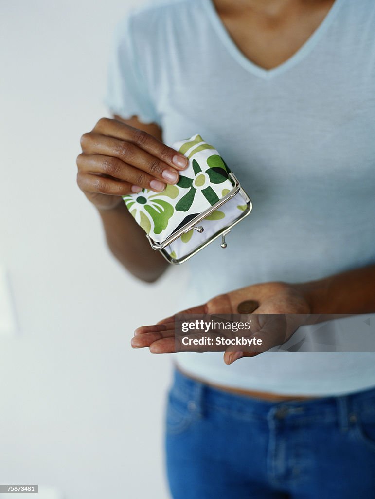 Woman holding wallet and coin