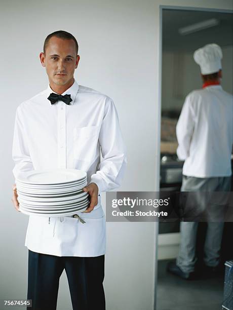 waiter holding stack of plates - waiter-stack-of-dishes stock pictures, royalty-free photos & images