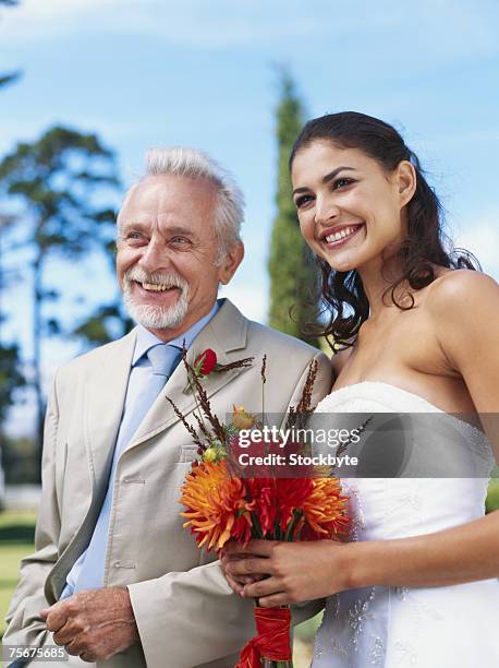 bride standing with mature man smiling - père de la mariée photos et images de collection