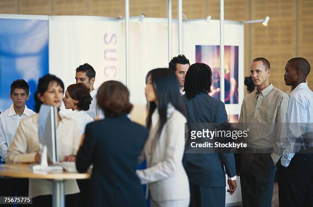 business executives standing in exhibition hall - exhibition foto e immagini stock