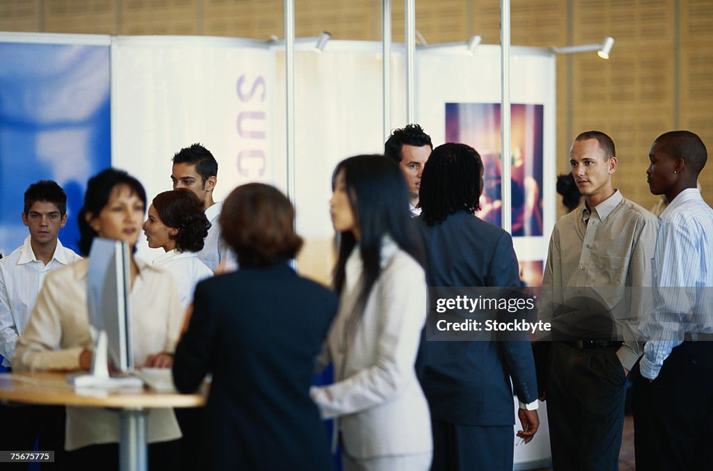 Business executives standing in exhibition hall