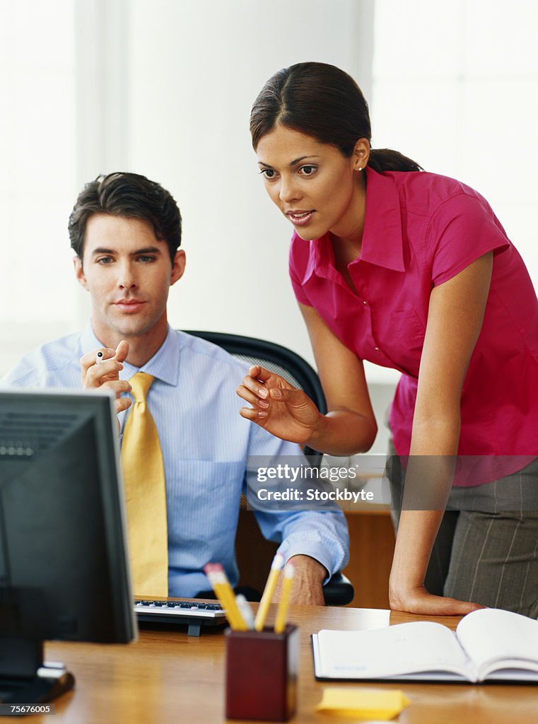 Businessman and woman using computer