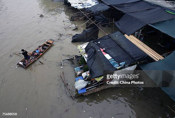 Woman travels by boat to reach her market inundated by floodwaters on the shores of the Yangtze River July 26, 2007 in Wuhan of Hubei Province,...